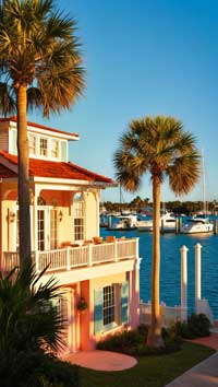 A house with a beautiful view of the harbor, featuring several yachts below