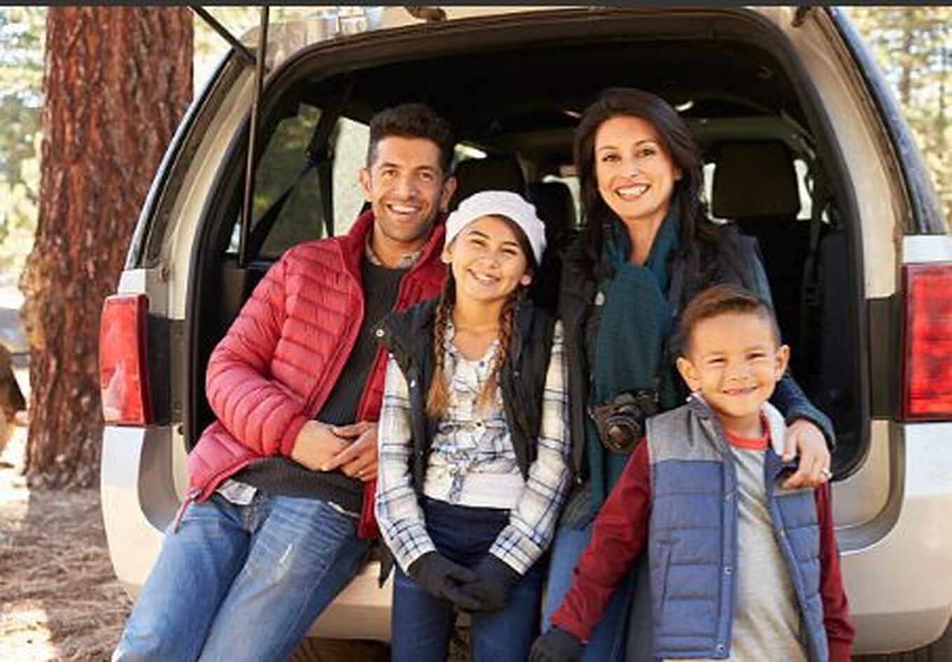 Familia latina junto a su auto durante una reseña de Farmers Insurance
