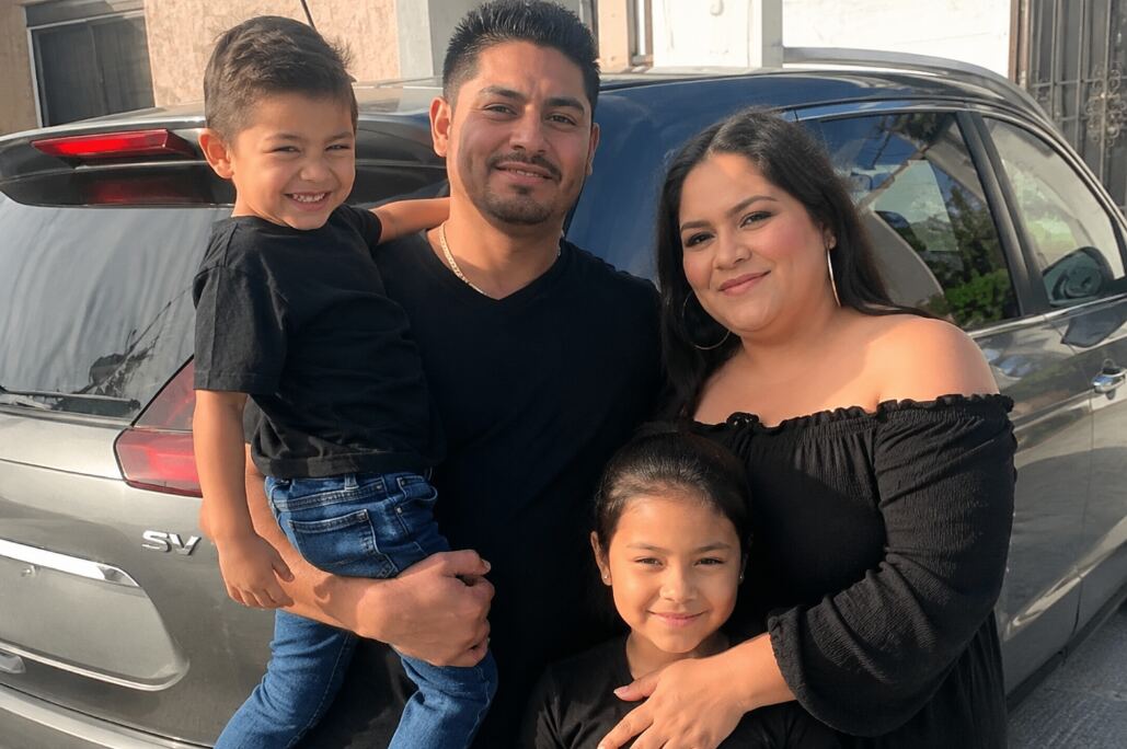 Familia latina junto a un vehículo al evaluar un seguro de auto de Arbella Insurance